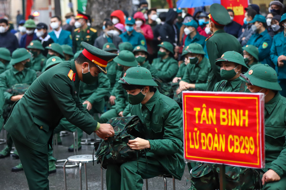 Một tân binh được chỉ huy hỗ trợ sửa soạn lại balo trước khi lên đường. (Ảnh: Minh Sơn/Vietnam+)