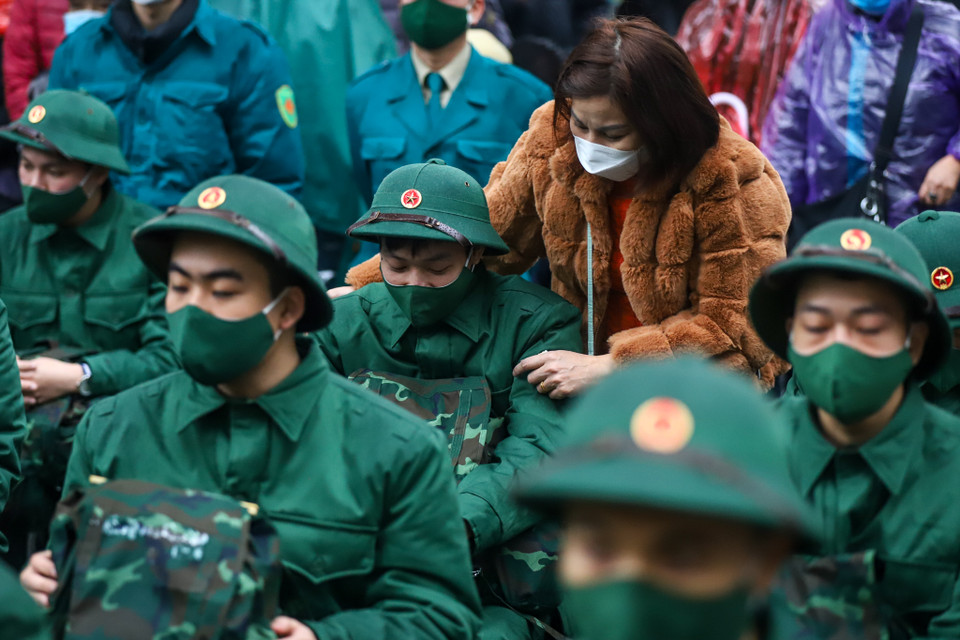 Lần đầu tiên trong đời, những tân binh được xỏ chân vào đôi giày lính, khoác trên vai chiếc balo lính. (Ảnh: Minh Sơn/Vietnam+)