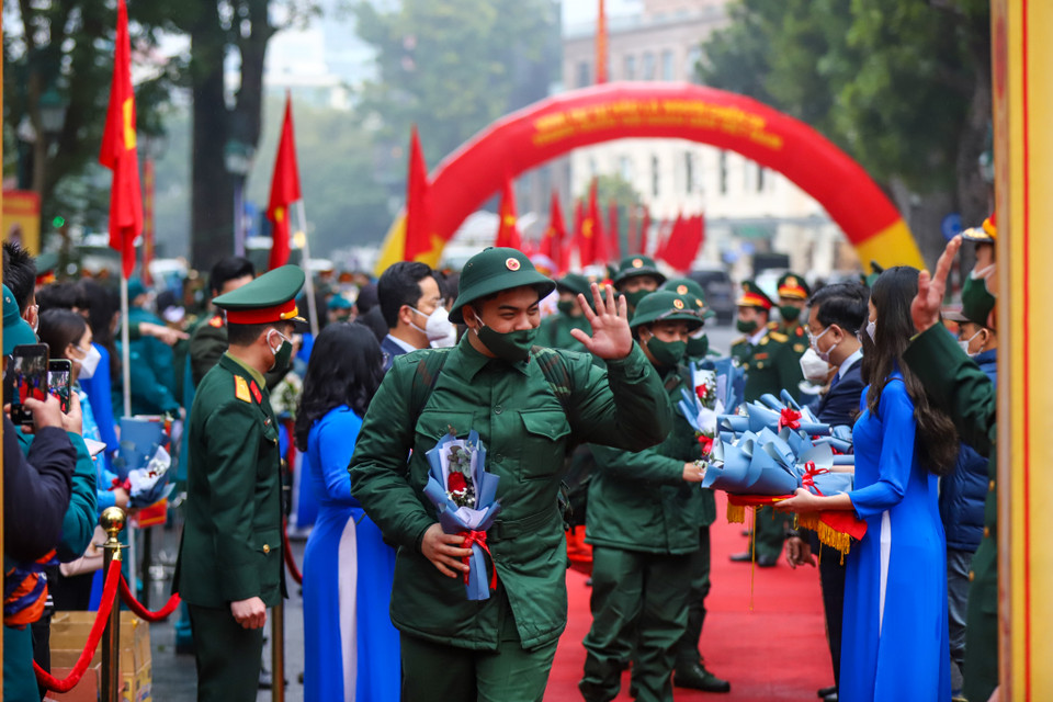 Tân binh bước qua cổng vinh quang để lên đường tham gia nghĩa vụ quân sự. Nhiều tân binh tặng lại hoa cho người thân. (Ảnh: Minh Sơn/Vietnam+)