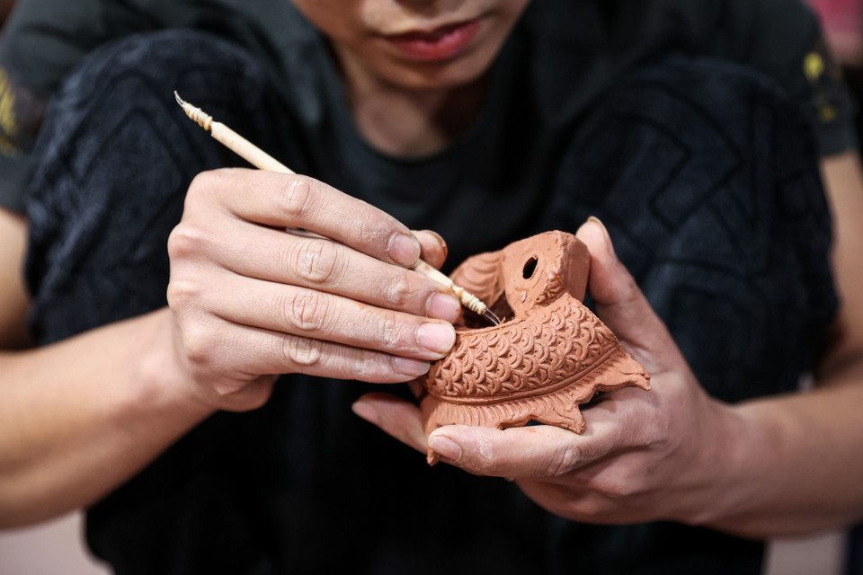 Ông Nguyễn Văn Lực, người đặt hàng tại xưởng này cho biết năm nay doanh nghiệp của ông bày bán sản phẩm Kỳ Linh Giáp Thìn 2024 với chủ đề "Dấu Ấn Rồng Thiêng." Bộ sưu tập được tạo hình dựa trên các đường nét bí ẩn Rồng thời Lê đang được trang trí tại Điện Kính Thiên - Hoàng thành Thăng Long. (Ảnh: Minh Sơn/Vietnam+)