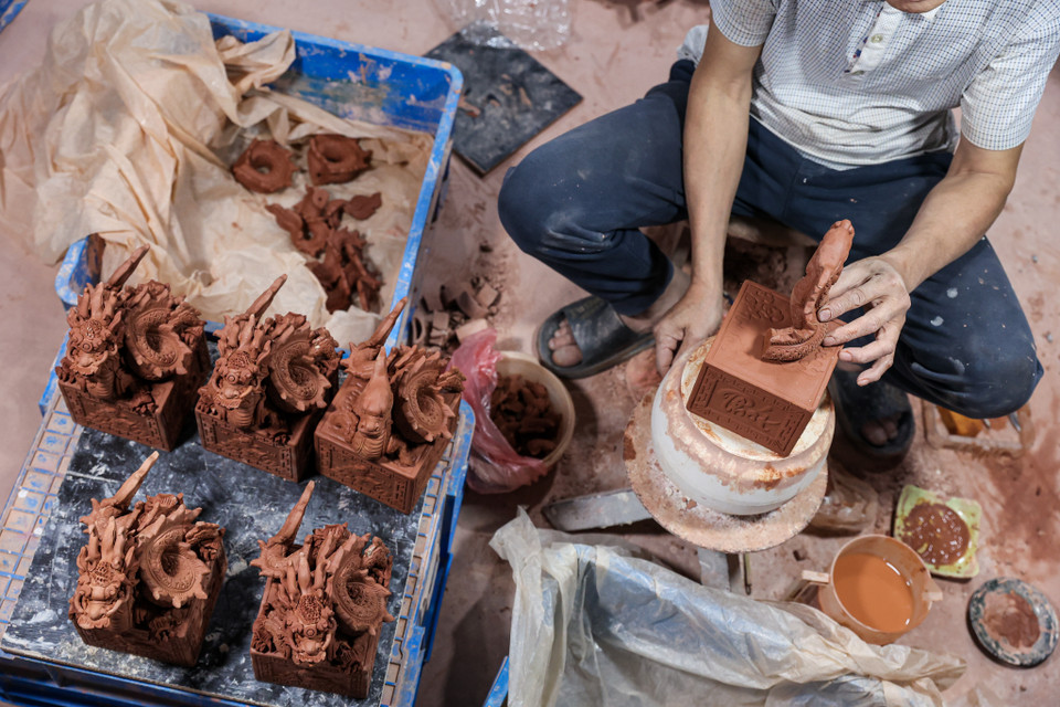 Ông Khoa chia sẻ để hoàn thiện một sản phẩm rồng bằng gốm sứ phải trải qua nhiều công đoạn tỉ mỉ. Dịp cận Tết, ông cùng các đồng nghiệp có thể làm đến 12 tiếng/ngày để kịp tiến độ. (Ảnh: Minh Sơn/Vietnam+)