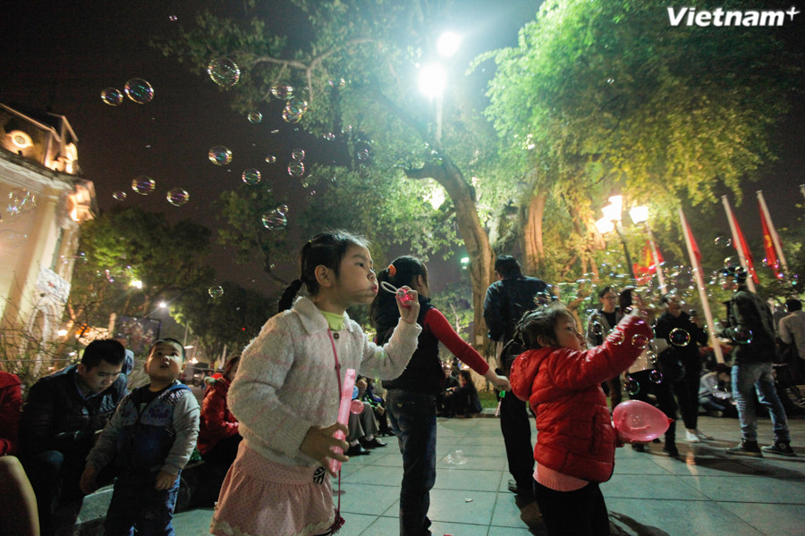 Các bé ở tượng đài Lý Thái Tổ đùa nghịch với bong bóng. (Ảnh: Thành Nguyễn/Vietnam+)