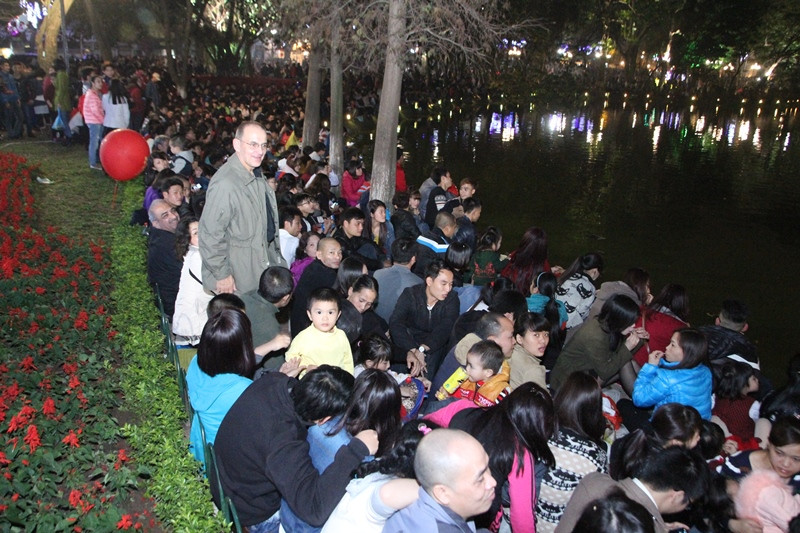 Người dân đã tụ tập kín xung quanh bờ hồ để xem bắn pháo hoa. (Ảnh: Thành Nguyễn/Vietnam+)