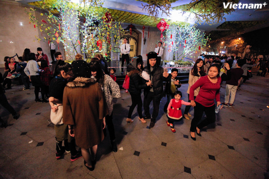 Và cũng đã lâu lắm, người Hà Nội mới lại rủ nhau xúng xính quần áo, ra đường thật sớm để đợi giây phút những chùm pháo hoa nổ tung trên bầu trời năm mới. (Ảnh: Thành Nguyễn/Vietnam+) 