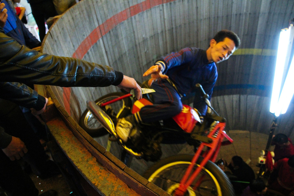 Nhiều khán giả thích thú khi xem trình diễn đã thưởng cho các ‘tay lái lụa’. Cá nghệ sỹ biểu diễn cũng rất tài tình khi nhận tiền thưởng của khán giả. (Ảnh: Minh Sơn/Vietnam+)