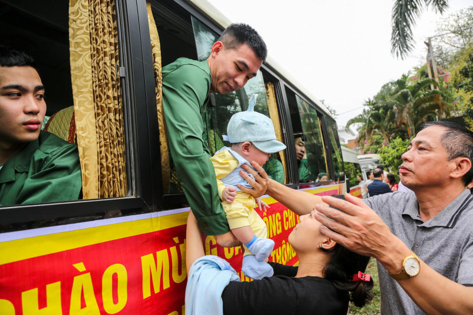 Tân binh Tạ Quang Hiếu sinh năm 1995 ôm cháu mình trước khi chia tay gia đình và người thân lên đường nhập ngũ. (Ảnh: Minh Sơn/Vietnam+)