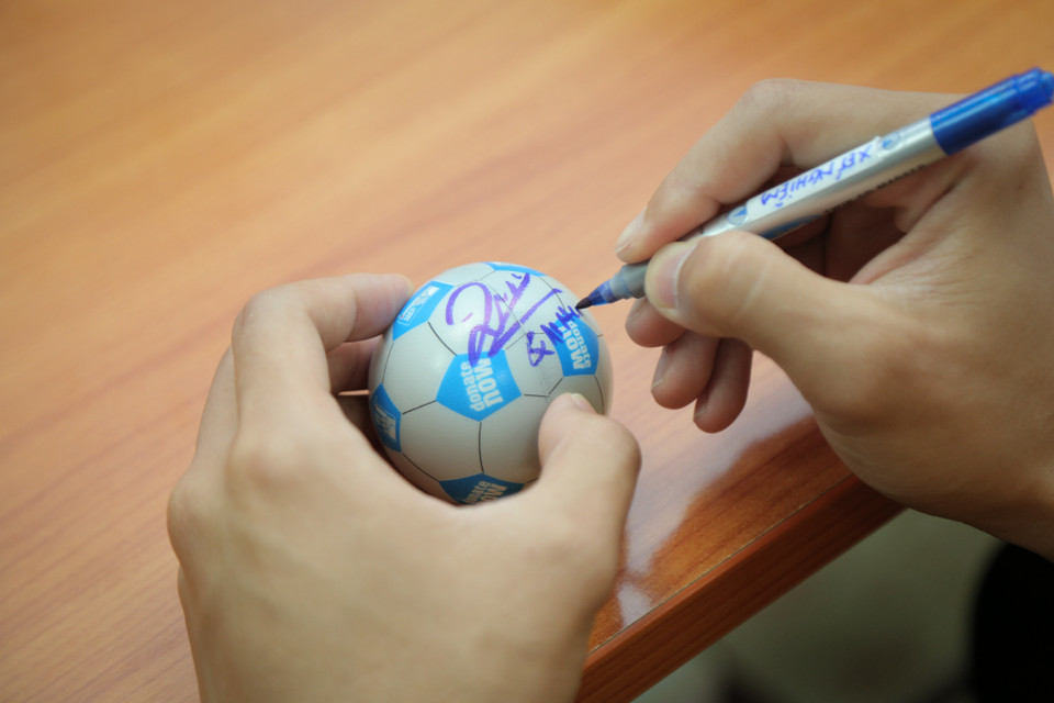 Quế Ngọc Hải ký lên những quả bóng mini để làm quà kỷ niệm cho các bệnh nhi. (Ảnh: PV/Vietnam+)