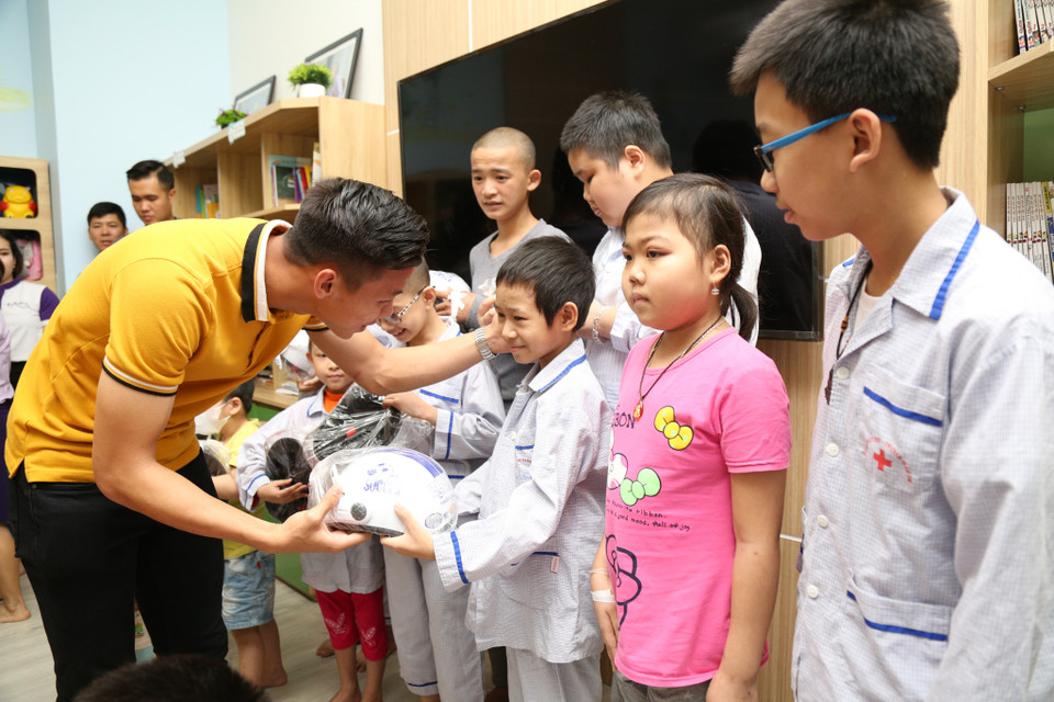 Hải trao quà cho các em (Ảnh: PV/Vietnam+)