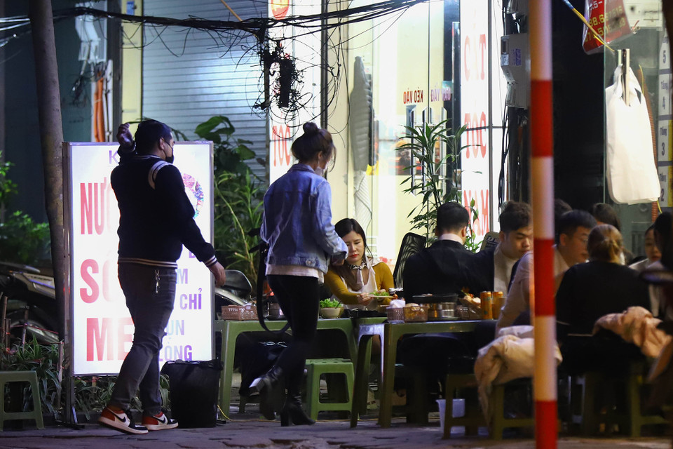 Khoảng thời gian từ 19 giờ-20 giờ, các quán vỉa hè luôn tấp nập khách hàng. Tại các quán này không hề có đồ khử khuẩn hay kê bàn ghế giãn cách nhau. (Ảnh: Hoài Nam/Vietnam+)