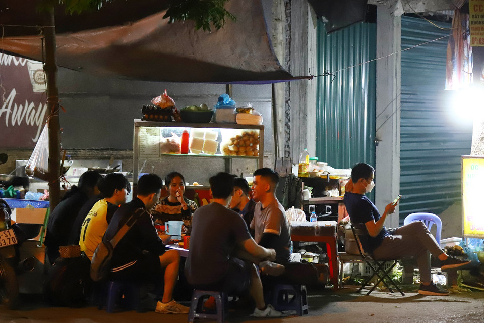 Tại phố Nguyễn Ngọc Vũ (quận Cầu Giấy), một số quán trong ngõ sâu thì dễ bề hoạt động hơn vì không có lực lượng chức năng vào trong kiểm tra, khách hàng tập trung đông nhưng không đeo khẩu trang. (Ảnh: Hoài Nam/Vietnam+)