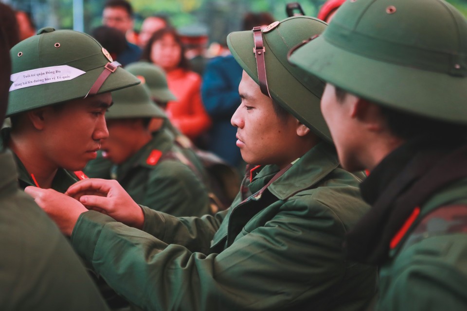 Các tân binh chỉnh sửa lại quân tư trang trước giờ lên đường. (Ảnh: Minh Sơn/Vietnam+)
