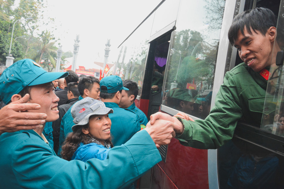 Những cái bắt tay chúc mừng người thân đi thực hiện nghĩa vụ. (Ảnh: Minh Sơn/Vietnam+)