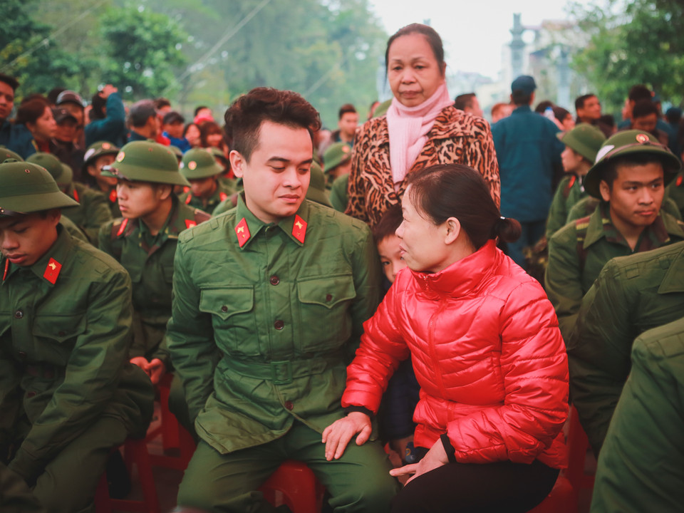 Gia đình bịn rịn dặn dò con em trước khi lên đường đi thực hiện nghĩa vụ thiêng liêng của Tổ quốc. (Ảnh: Minh Sơn/Vietnam+)