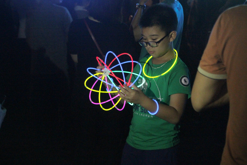 Những que phát sáng vẫn là vật dụng được yêu thích tại mỗi sự kiện tắt đèn. (Ảnh: Minh Sơn/Vietnam+)