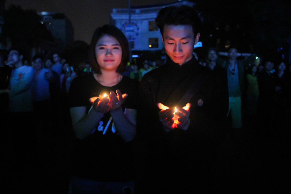 Không dùng những thiết bị điện trong suốt 60 phút tắt đèn, nhiều người dân đã chọn cách thắp nến. (Ảnh: Minh Sơn/Vietnam+)