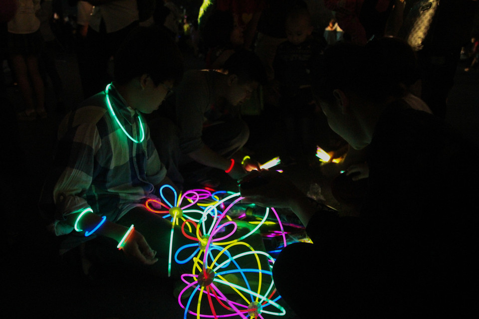 Các bạn trẻ đang tạo nhiều hình thù khác nhau từ que phát sáng. (Ảnh: Minh Sơn/Vietnam+)
