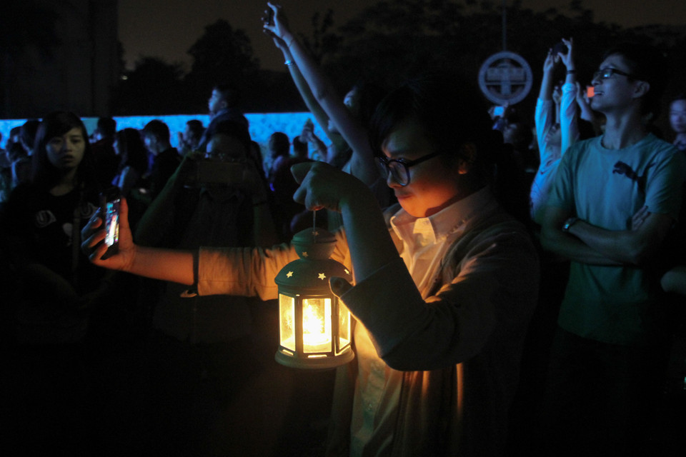 Một bạn nữ đã chọn cho mình một chiếc đèn cầy để tham gia sự kiện lớn về môi trường trong năm này . (Ảnh: Minh Sơn/Vietnam+)