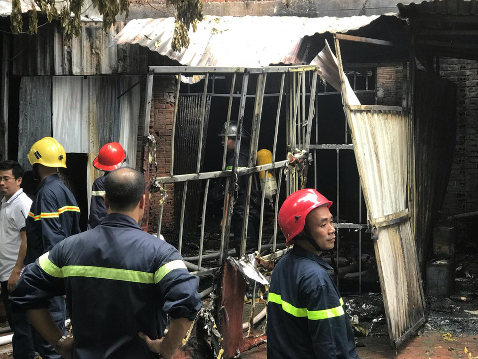 Lửa dữ dội nhanh chóng bốc lên và lan sang căn nhà bên cạnh. Đáng chú ý, hai căn nhà trên đều là các biệt thự đang hoàn thiện và được chủ nhân cho thuê lại để làm xưởng hoặc để ở. Phía ngoài được lợp mái tôn che chắn để nới rộng diện tích. (Ảnh: PV/Vietnam+)