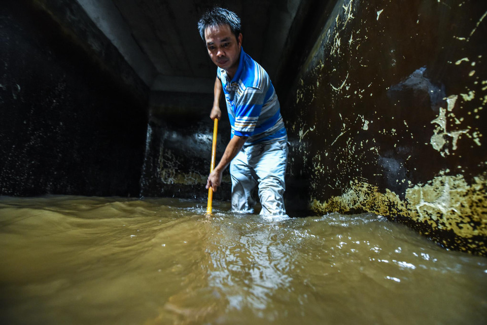Anh Dũng, nhân viên công ty Viwaco cho biết từ vài ngày nay công việc chính của anh là đi thau rửa bể nước sinh hoạt cho hàng loạt tòa chung cư trong khu vực quận Cầu Giấy. (Ảnh: PV/Vietnam+)