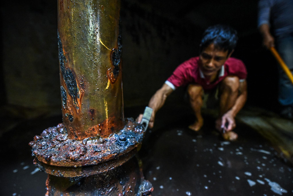 Ông Tạ Hùng, một cư dân tòa nhà khi phối hợp cùng đội công nhân đã phát hiện không khí dưới bể ngầm có mùi khét rất khó chịu, còn nước thì đen kịt. (Ảnh: PV/Vietnam+)