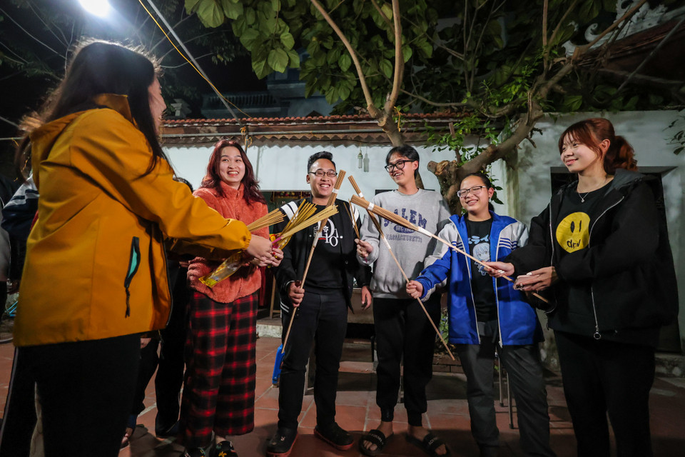 20 giờ 45 phút, trong khi các vị cao niên bắt đầu nghi lễ truyền thống thì hàng trăm người đã có mặt ở sân đình, tay cầm hương chờ đợi. (Ảnh: Minh Sơn/Vietnam+)