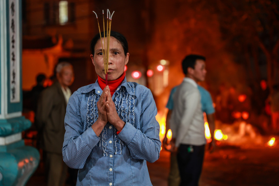 Nhiều người 'lấy đỏ' xong không mang về nhà ngay mà mang vào đình khấn vái. (Ảnh: Minh Sơn/Vietnam+)