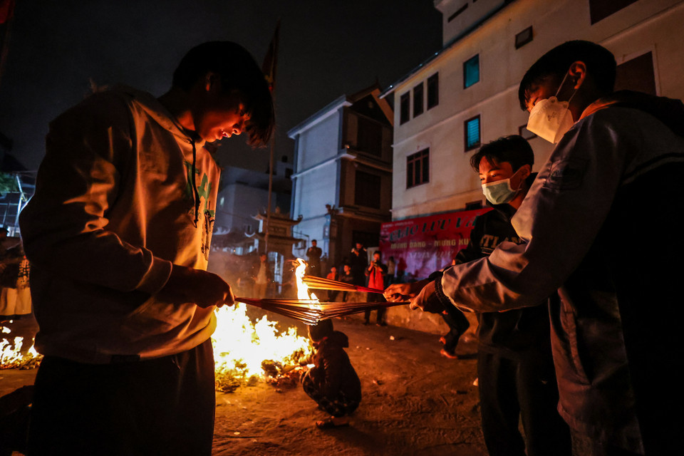 Mọi người đều cố gắng lấy bó hương to, giữ ngọn lửa lớn trên đường về tránh bị dập tắt. (Ảnh: Minh Sơn/Vietnam+)
