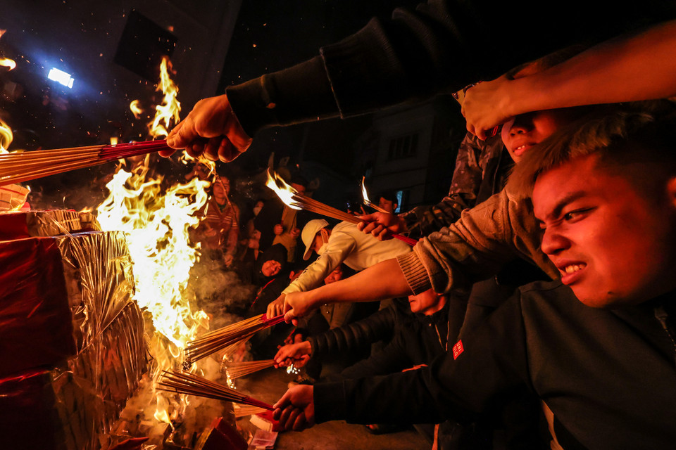 Với quan niệm, đã 'xin đỏ' thì phải lấy trọn bộ, ngoài hoa quả được phát người đến lấy lửa phải mang cả đồ đã hóa vàng về. (Ảnh: Minh Sơn/Vietnam+)