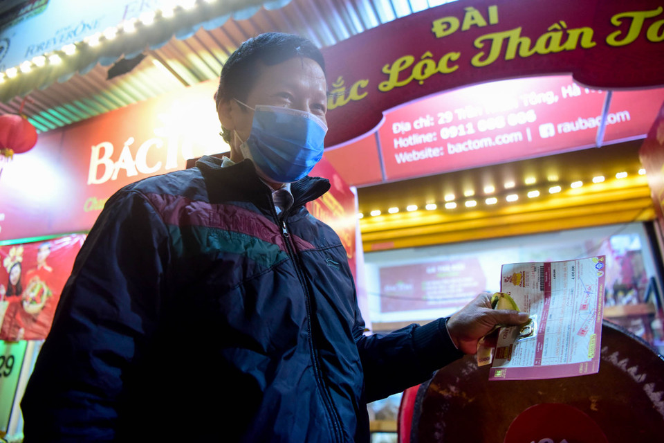 Ông Đào Văn Hảo (56 tuổi, ở Hoàng Mai) là khách hàng đầu tiên của cửa hàng vàng bạc Bảo Tín Minh Châu ở số 29 Trần Nhân Tông chia sẻ: "Tôi đến xếp hàng từ 3h sáng để mua vàng. Năm ngoái tôi cũng đến xếp hàng giờ này nhưng đông quá nên không được xếp đầu tiên". (Ảnh: Minh Sơn/Vietnam+)