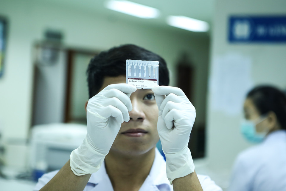 Sau khi xét nghiệm nhóm máu, các nhân viên sẽ tiến hành xét nghiệm sàng lọc. (Ảnh: Minh Sơn/Vietnam+)