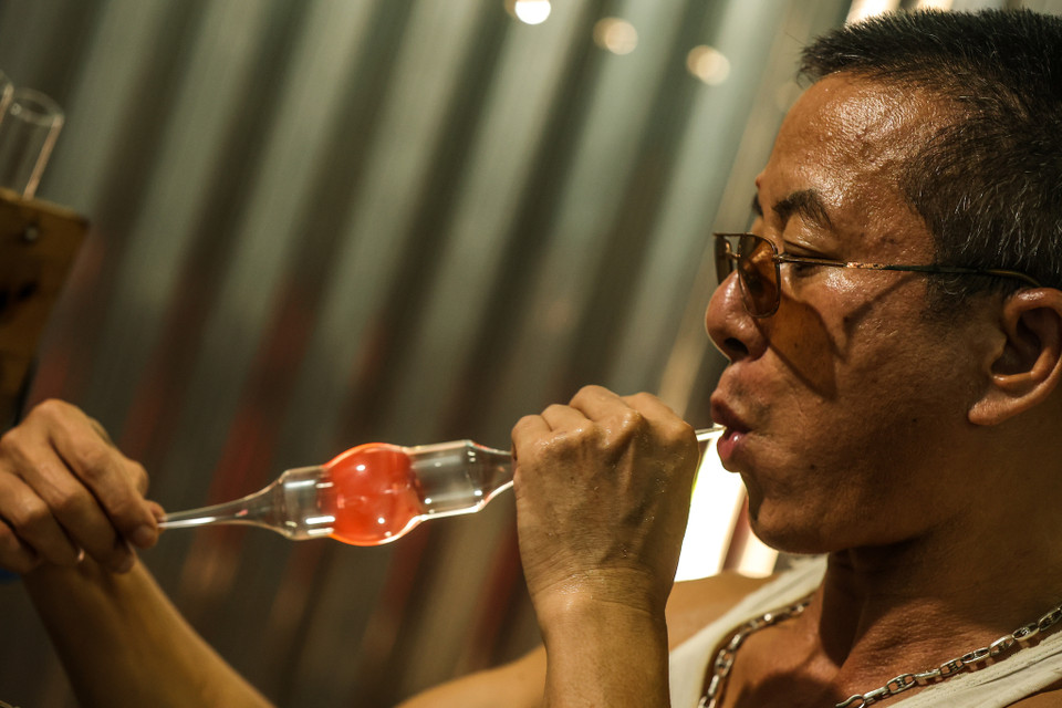 Quá trình tạo hình sản phẩm cũng được người thợ áp dụng trong lúc thổi. Trong tất cả các bước thì kỹ thuật thổi là quan trọng nhất. Người thợ phải sử dụng hơi thở thật khéo léo cho phù hợp với từng loại sản phẩm làm ra. (Ảnh: Minh Sơn/Vietnam+)