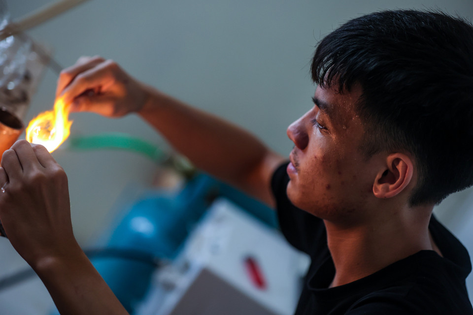 Xưởng nhà ông Tiến có quy mô nhỏ, mặt hàng chủ yếu là lọ thủy tinh cho chim ăn. Nếu làm đều đặn mỗi ngày xưởng có thể sản xuất hàng trăm sản phẩm. (Ảnh: Minh Sơn/Vietnam+)