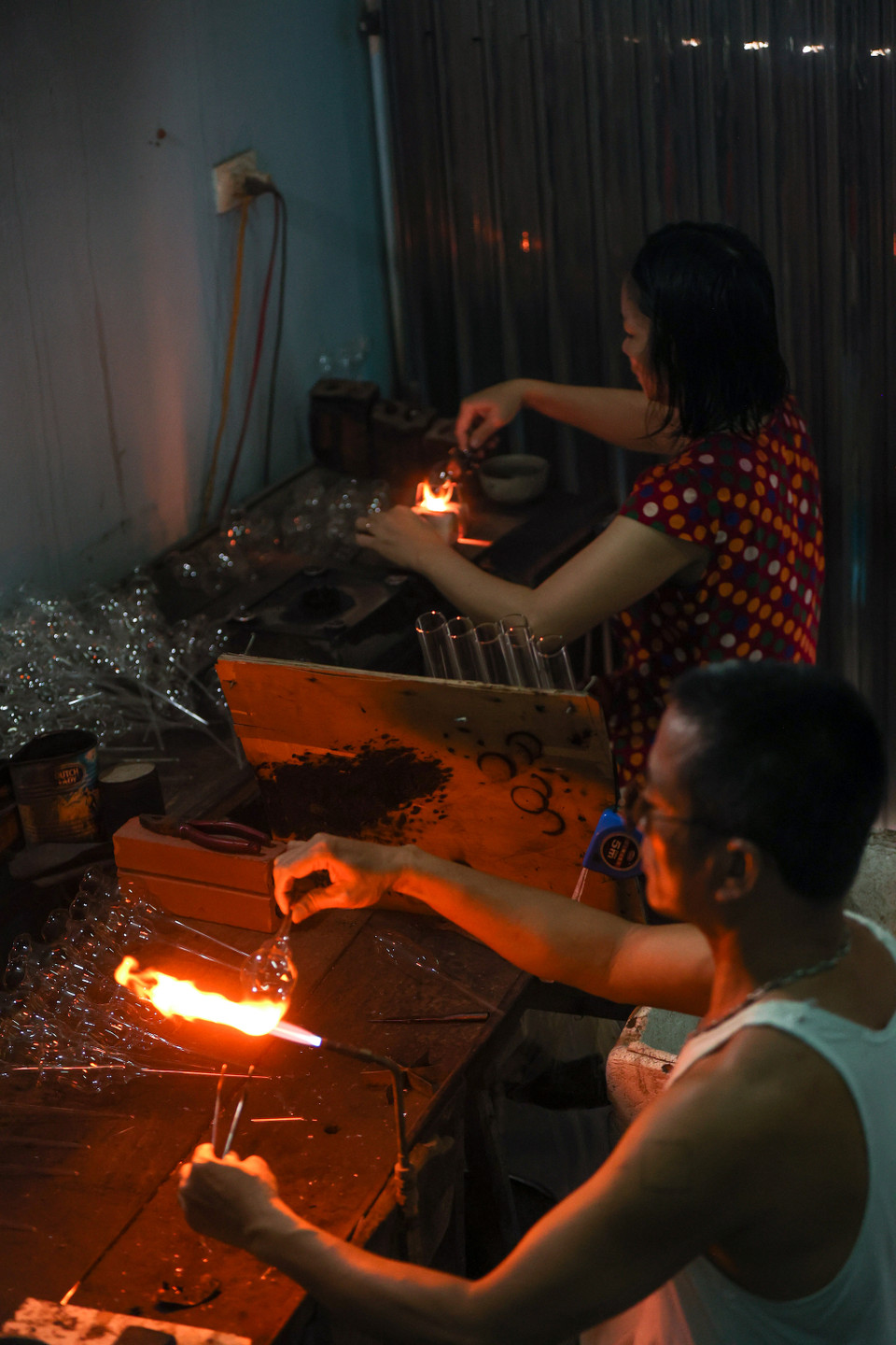 Nhiều hộ làm nghề thổi thủy tinh truyền thống ở xã Thống Nhất hiện không chỉ sản xuất những đồ dùng thủy tinh truyền thống mà còn tìm tòi nghiên cứu để làm ra các vật dụng, thiết bị sử dụng trong lĩnh vực y tế, giáo dục. (Ảnh: Minh Sơn/Vietnam+)