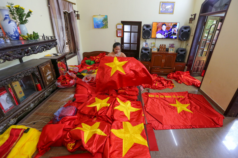 Chị Nhung tự hào khoe về cô con gái năm nay mới 23 tuổi, nhưng cũng đã có hơn 11 năm kinh nghiệm trong nghề thêu cờ. (Ảnh: Minh Sơn/Vietnam+)