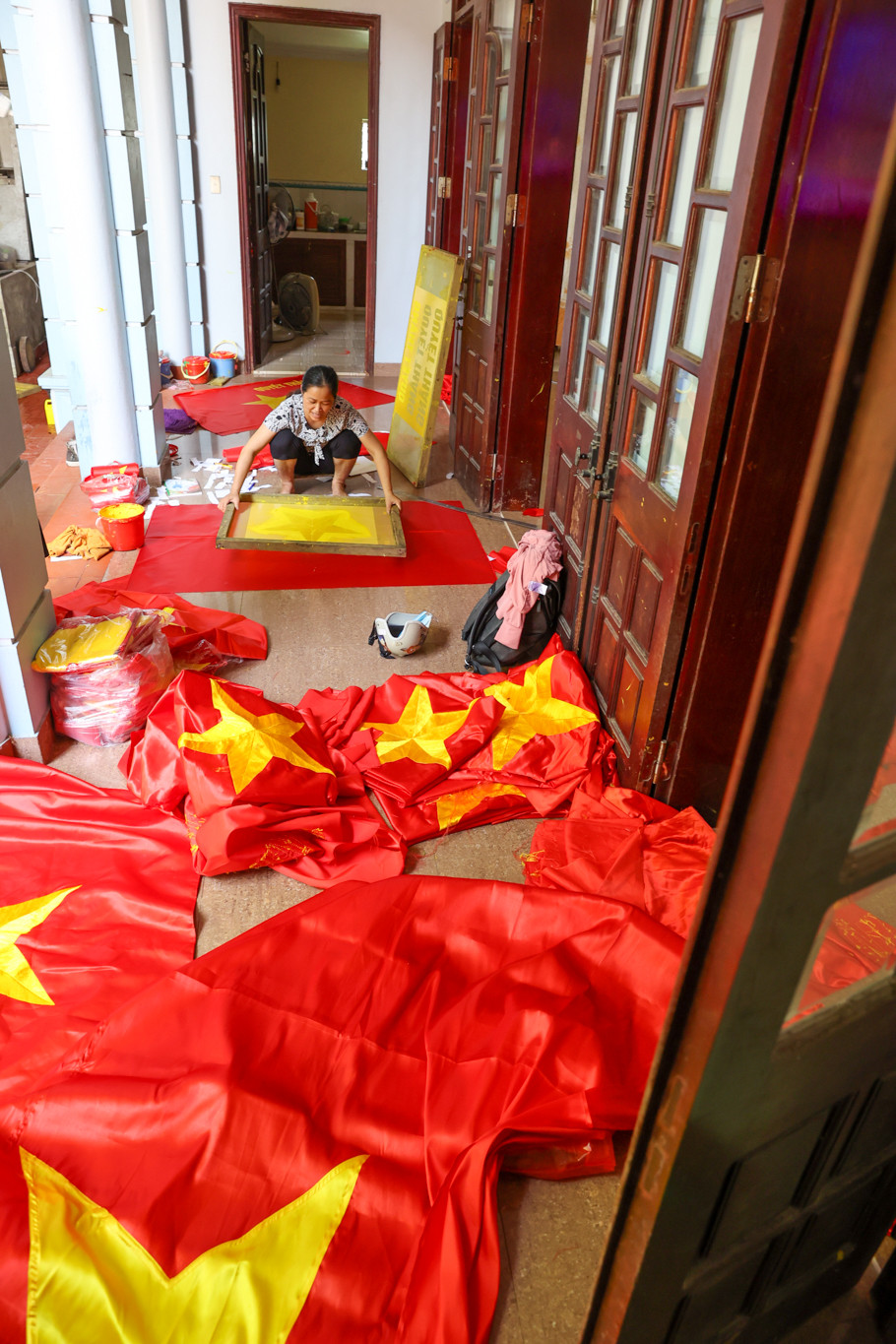 “Ngày trước, cứ mỗi ngày, bố tôi sẽ chở cờ bằng xe đạp lên phố Hàng Bông (Hoàn Kiếm, Hà Nội) giao cho khách, 94 tuổi nhưng ông cụ vẫn đạp xe mấy chục cây số đi giao cờ. Ông cụ thọ 104 tuổi, cũng là những người đầu tiên đem nghề làm cờ về làng,” chị Nhung tự hào chia sẻ. (Ảnh: Minh Sơn/Vietnam+)