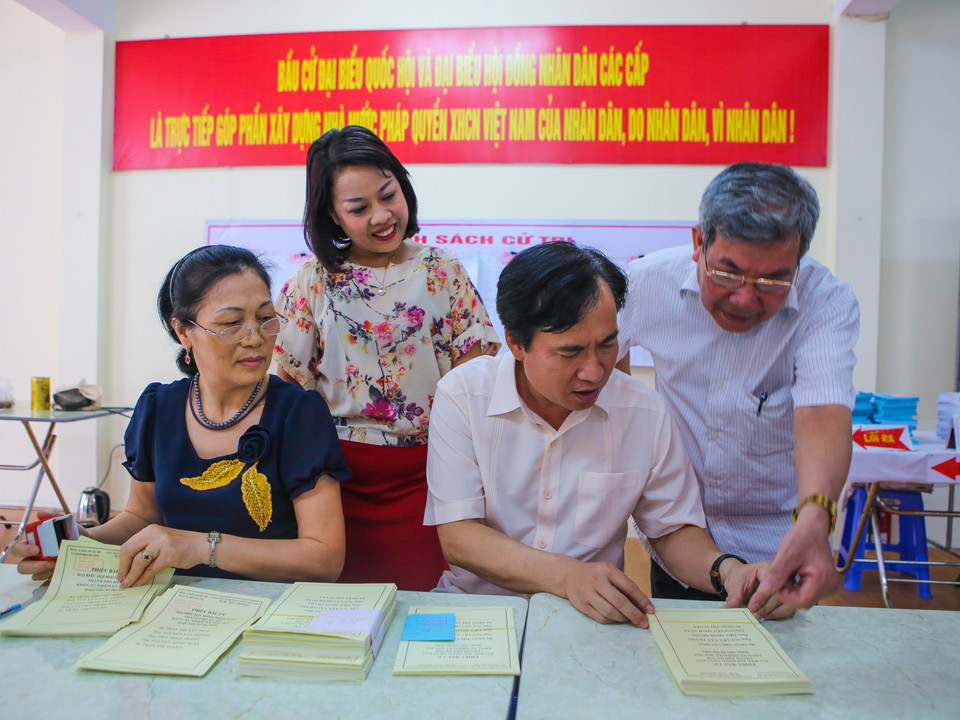 Tại các điểm bỏ phiếu, người dân đang nhanh chóng hoàn thành các công tác chuẩn bị cho ngày bầu cử. (Ảnh: PV/Vietnam+)