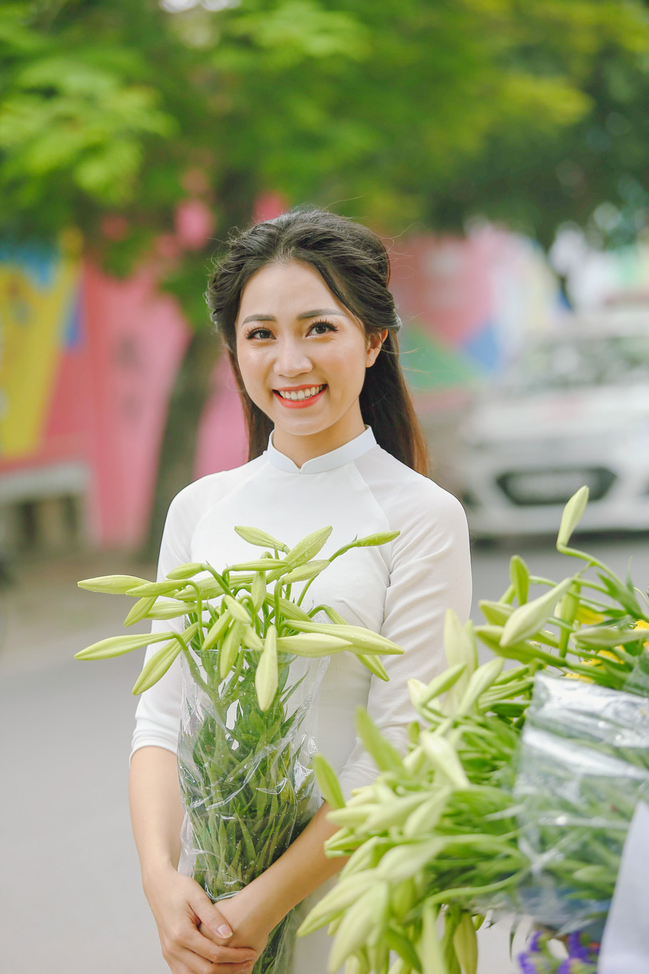 Hoa loa kèn thường nở vào dịp tháng 4 hằng năm. Mỗi khi hoa nở, trên đường phố lại nhộn nhịp những xe hoa bán rong cùng những cô gái e ấp chụp ảnh bên cạnh. (Ảnh: Thế Đại/Vietnam+)