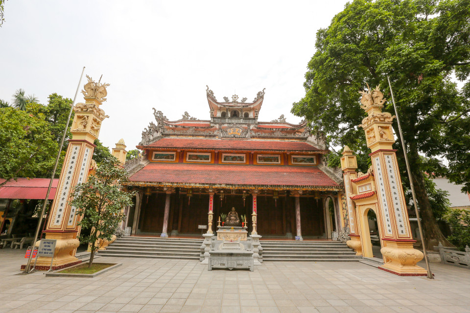 Sau dãy tường dài, ở phía trái toà Tam bảo có hồ nước và xung quanh chùa là vườn cây mát mẻ. Tam quan to rộng với gác chuông rất cao được xây sát mặt phố. (Ảnh: Minh Sơn/Vietnam+)