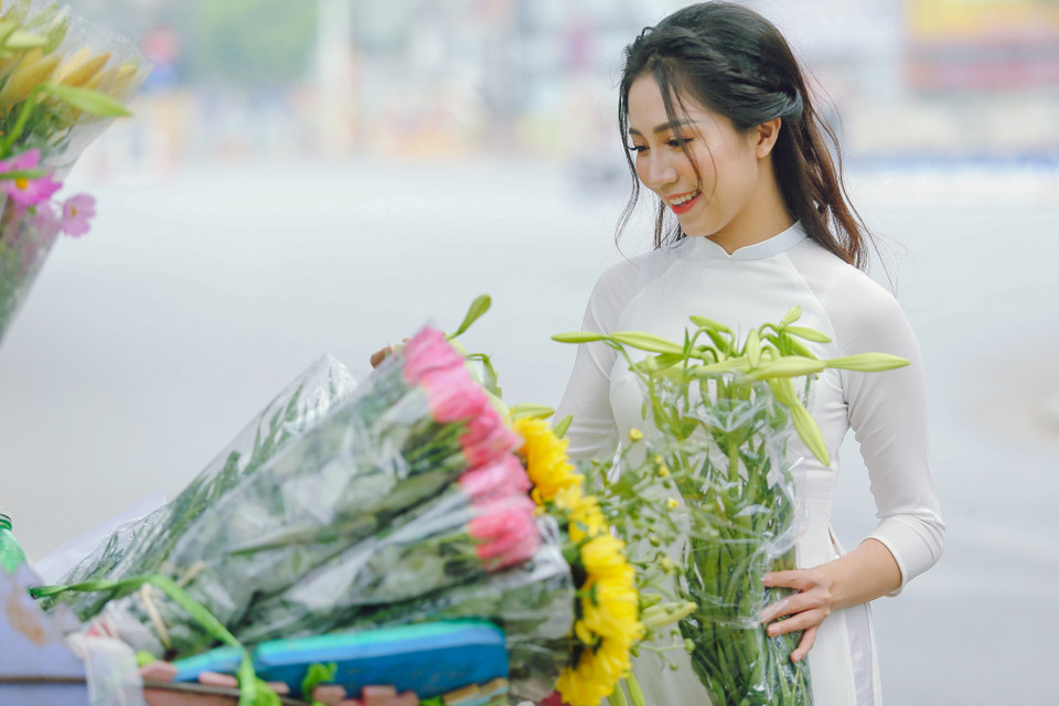 Giữa những xô bồ và ồn ã, những người yêu hoa tận hưởng cảm giác thư thái khi mua những bông hoa loa kèn, để mà thưởng thức vẻ đẹp chỉ có một lần trong năm ở Hà Nội. (Ảnh: Thế Đại/Vietnam+)