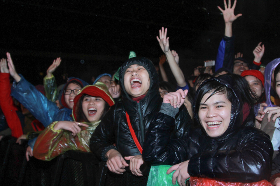 Hàng ngàn khán giả Thủ đô đội mưa hòa chung nhịp đập cùng Rockstorm. (Ảnh: Minh Sơn-Thành Nguyễn/Vietnam+)