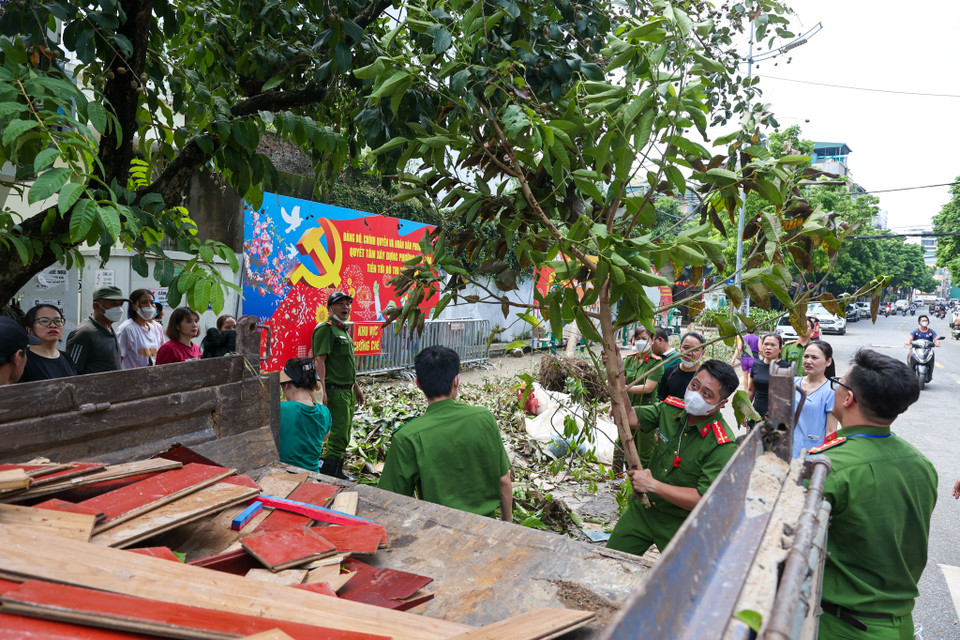 Lực lượng công an, dân quân tự vệ cũng tham gia hỗ trợ người dân dọn dẹp lại nhà cửa, khu phố, giúp nhanh chóng ổn định cuộc sống. (Ảnh: Minh Sơn/Vietnam+)