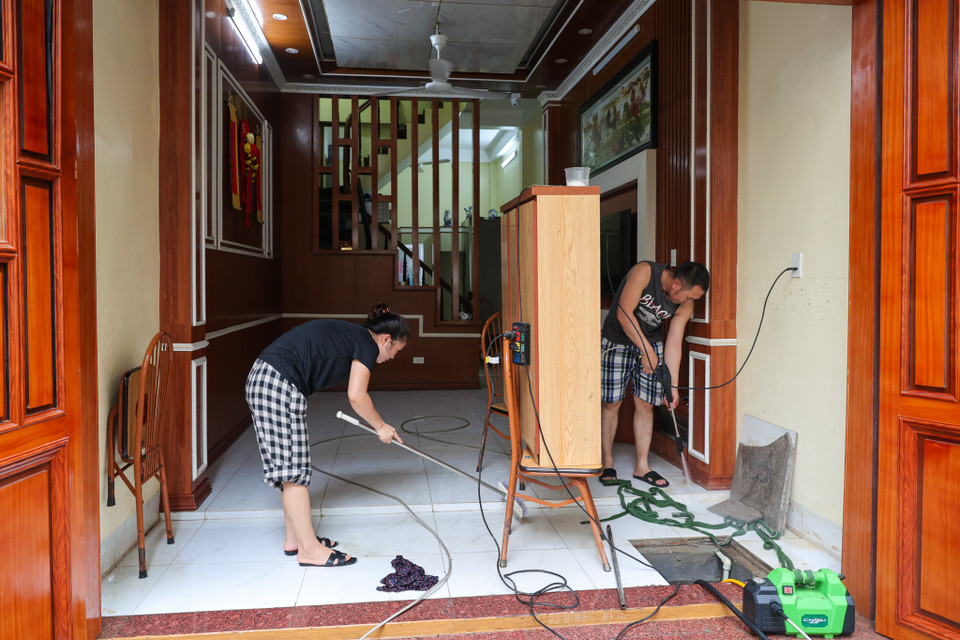 Một cư dân Tứ Liên chia sẻ: "Nhà tôi bị ngập gần đến nửa tường, tất cả đồ đạc ở tầng trệt đều bị ướt sũng. Chúng tôi chỉ mong mọi thứ sớm trở lại bình thường." (Ảnh: Minh Sơn/Vietnam+)