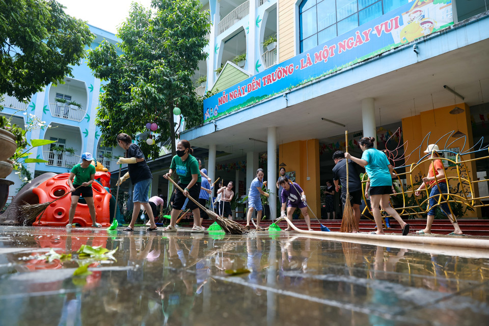 Bà Trần Thị Liên - Hiệu trưởng trường mần non Tứ Liên chia sẻ: "Trước tình hình lũ gây ngập úng, nhà trường thường xuyên theo dõi mực nước, chỉ cần nước rút xuống là lập tức huy động cán bộ nhân viên dọn vệ sinh. Ngay từ chiều qua chúng tôi đã bắt đầu vệ sinh ở khu vực tầng 1, ngày hôm nay nước tiếp tục rút ra khỏi sân trường chúng tôi cũng nhanh chóng dọn hết khu vực sân trường." (Ảnh: Minh Sơn/Vietnam+)