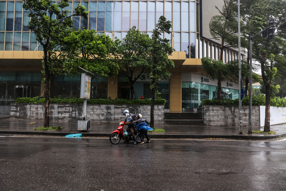 Thời điểm 12 giờ tại khu vực cầu vượt ngã tư Kim Mã - Liễu Giai, hàng loạt phương tiện đi qua đây khó khăn vì cơn mưa lớn. (Ảnh: Minh Sơn/Vietnam+)