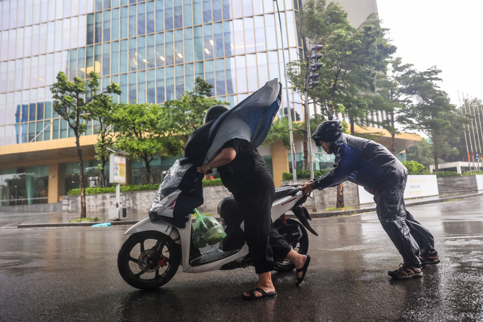 Nhiều phương tiện không để tiếp tục di chuyển được người dân xung quanh hỗ trợ đưa vào trú dưới gầm cầu vượt. (Ảnh: Minh Sơn/Vietnam+)