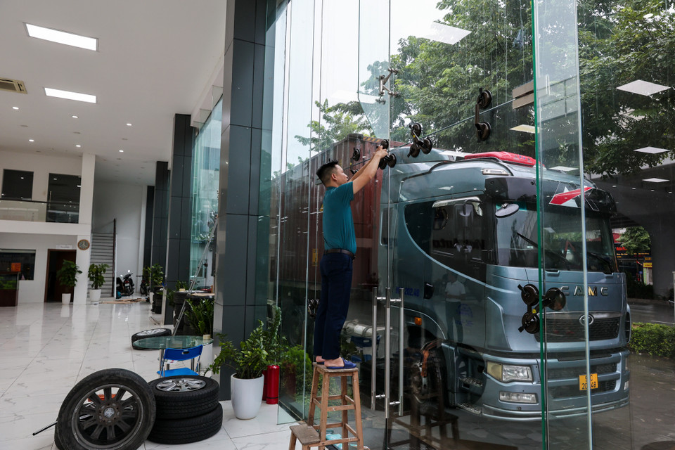 Đáng chú ý, một số cửa hàng dùng xe container chặn trước cửa, phòng gió 'giật' vỡ kính. (Ảnh: Minh Sơn/Vietnam+)