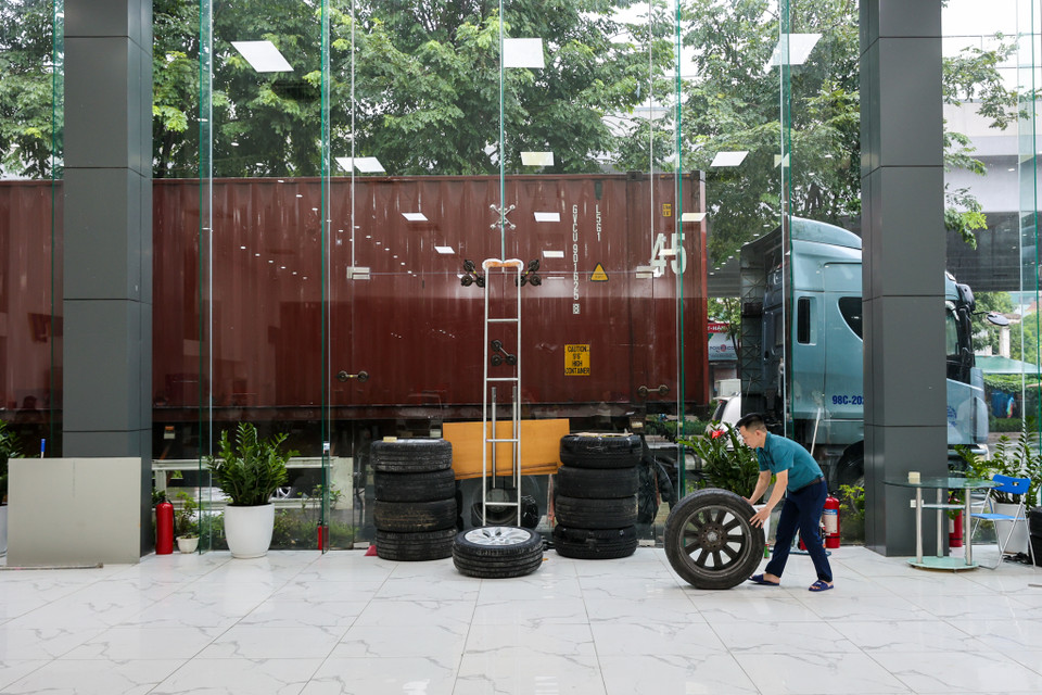 Một showroom bán ôtô trên đường Phạm Văn Đồng đang tích cực thực hiện các biện pháp phòng chống bão. (Ảnh: Minh Sơn/Vietnam+)