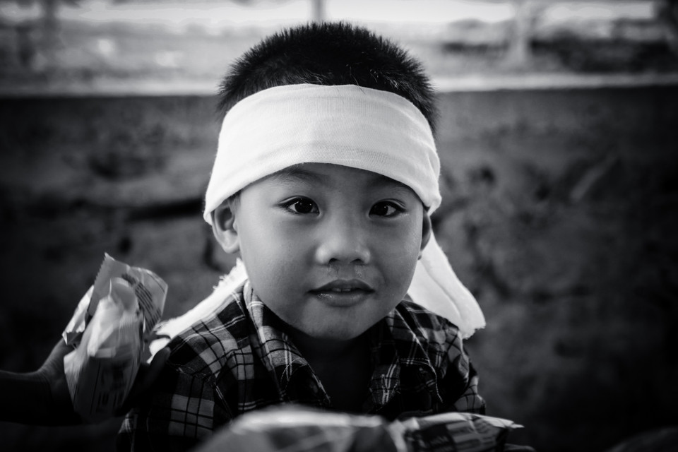 Khoảnh sân toàn đất nhà nạn nhân Nguyễn Văn Dũng (Lâm Trạch, Quảng Bình), con út của anh, cháu Nguyễn Văn Đức vẫn hồn nhiên cười đùa khi thấy khách lạ vào thăm. Ngày đưa anh về, mẹ mặc bé áo tang, bé còn tưởng được mẹ mua cho quần áo mới nên cười rất tươi, chạy đi khoe khắp xóm làng. Nó còn bé quá, chưa kịp nhận ra ba mất rồi. (Ảnh: PV/Vietnam+)