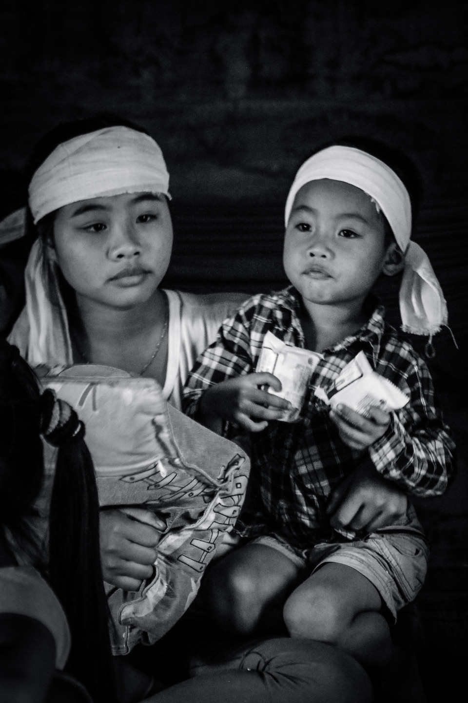 Đứa con gái lớn của anh Dũng ôm chặt đứa em trai bé bỏng. Em đã bỏ học mấy ngày trời, từ lúc biết tin bố mất, em gần như không ăn uống được gì. (Ảnh: PV/Vietnam+)