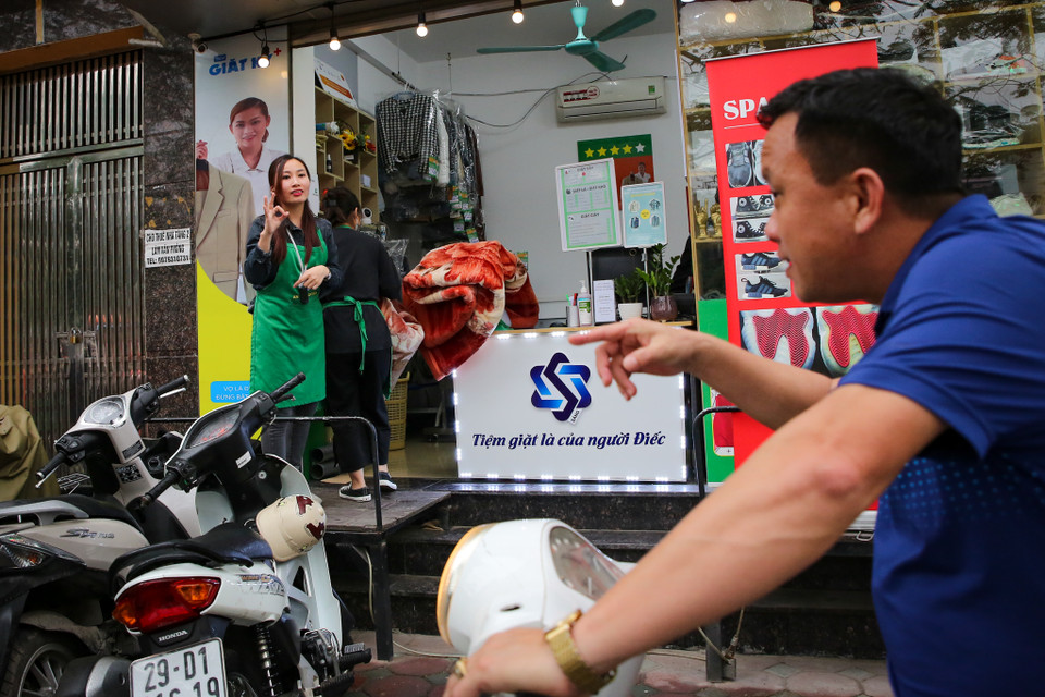 Chị Thuý hào hứng chia sẻ, những khách hàng quen chỉ việc mang đồ đến và không cần phải nói gì nữa. Nếu muốn yêu cầu thêm, họ chỉ làm những điệu bộ cử chỉ đơn giản để giao tiếp với nhân viên. (Ảnh: Minh Sơn/Vietnam+)